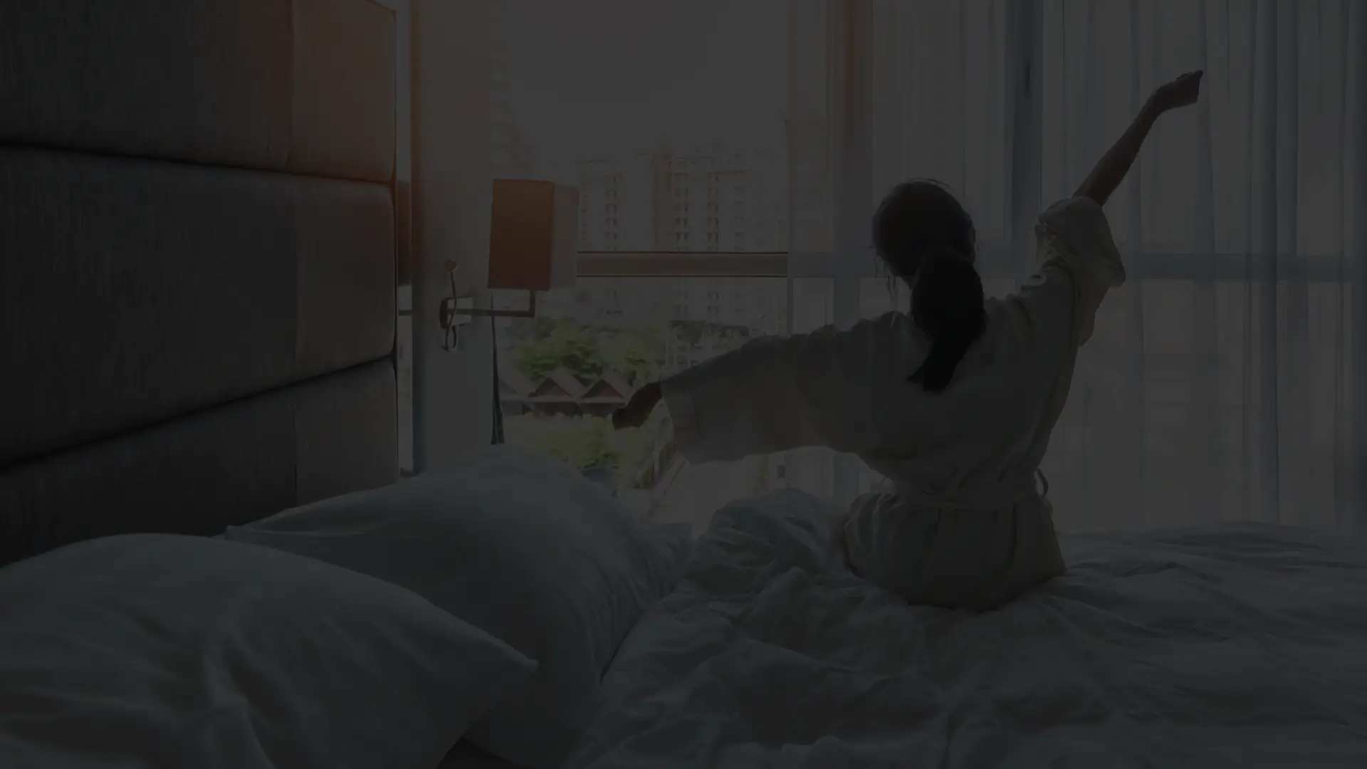 Kobieta siedząca na łóżku, na pościeli Anti Stress Bedding.